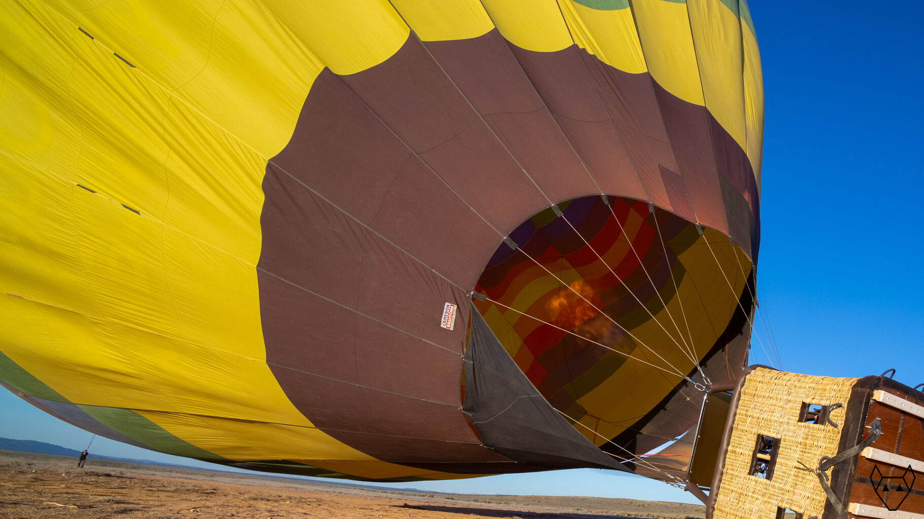Out in the mesa, a hot air balloon begins to rise.