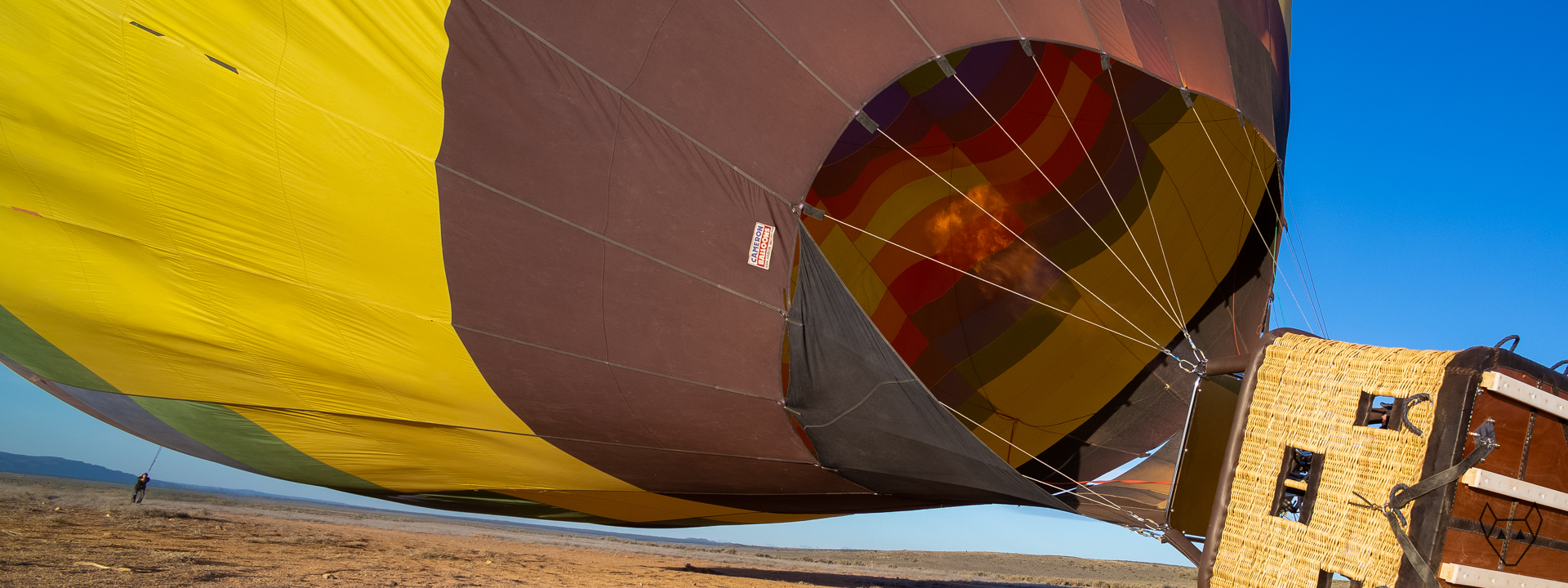 A yellow hot air balloon is beginning to rise.